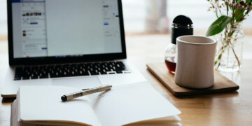 notebook in front of a laptop on a table