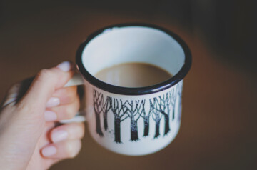 Woman with manicured nails holding coffee mug