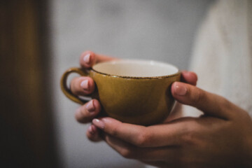 Woman holding coffee with painted nails