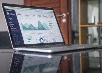 Laptop on a glass desk with analytics up