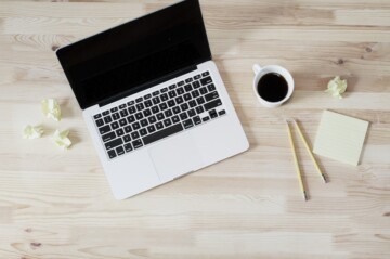 computer with papers on a desk