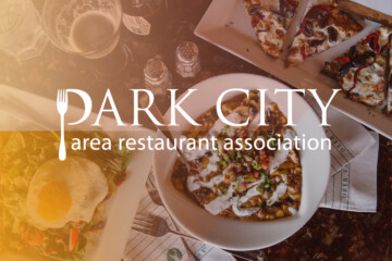 Park City Area Restaurant Association logo over a set table of food.