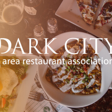 Park City Area Restaurant Association logo over a set table of food.