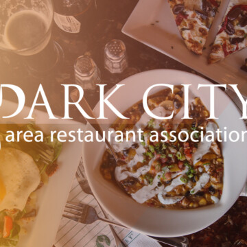 Park City Area Restaurant Association logo over a set table of food.