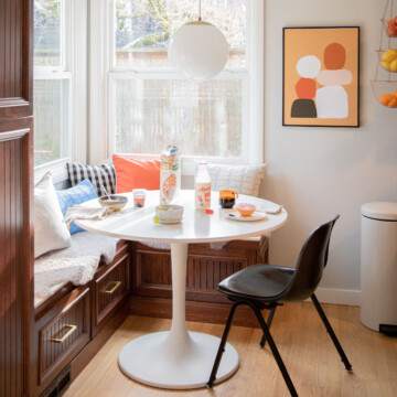 table with a chair and a couch in a room with a window