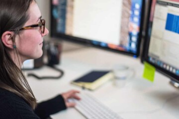 Woman working on a dual screen set up