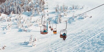 Ski lift on snowy mountain with trees
