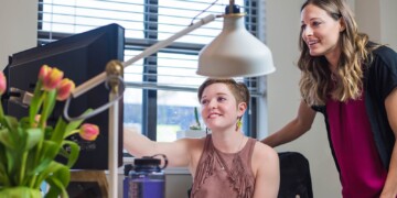 two people talking at a computer screen