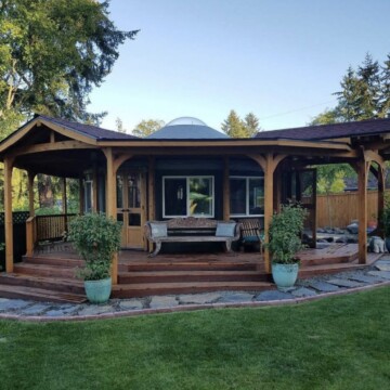 house with a porch and a tree in the back