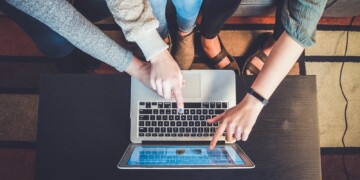 People pointing at a laptop screen