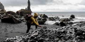 Person climbing rocks on a beach