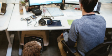 Man working on computer with dog