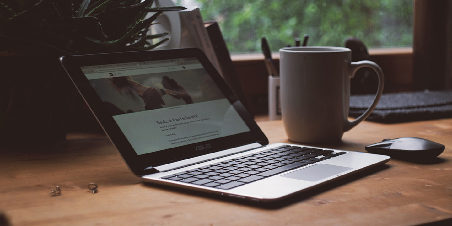 Computer on a desk with a cup of coffee