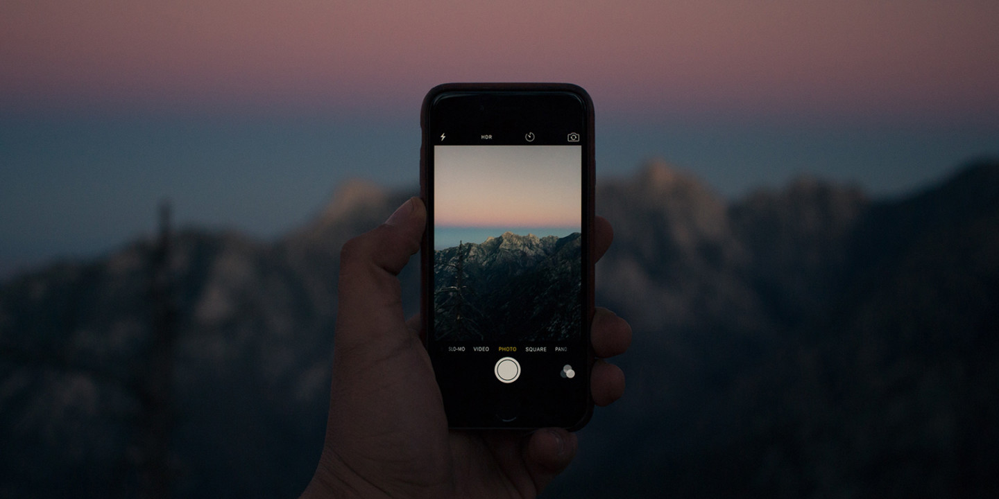 Person taking photo of a mountain for social media