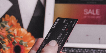 Person holding credit card in front of computer screen