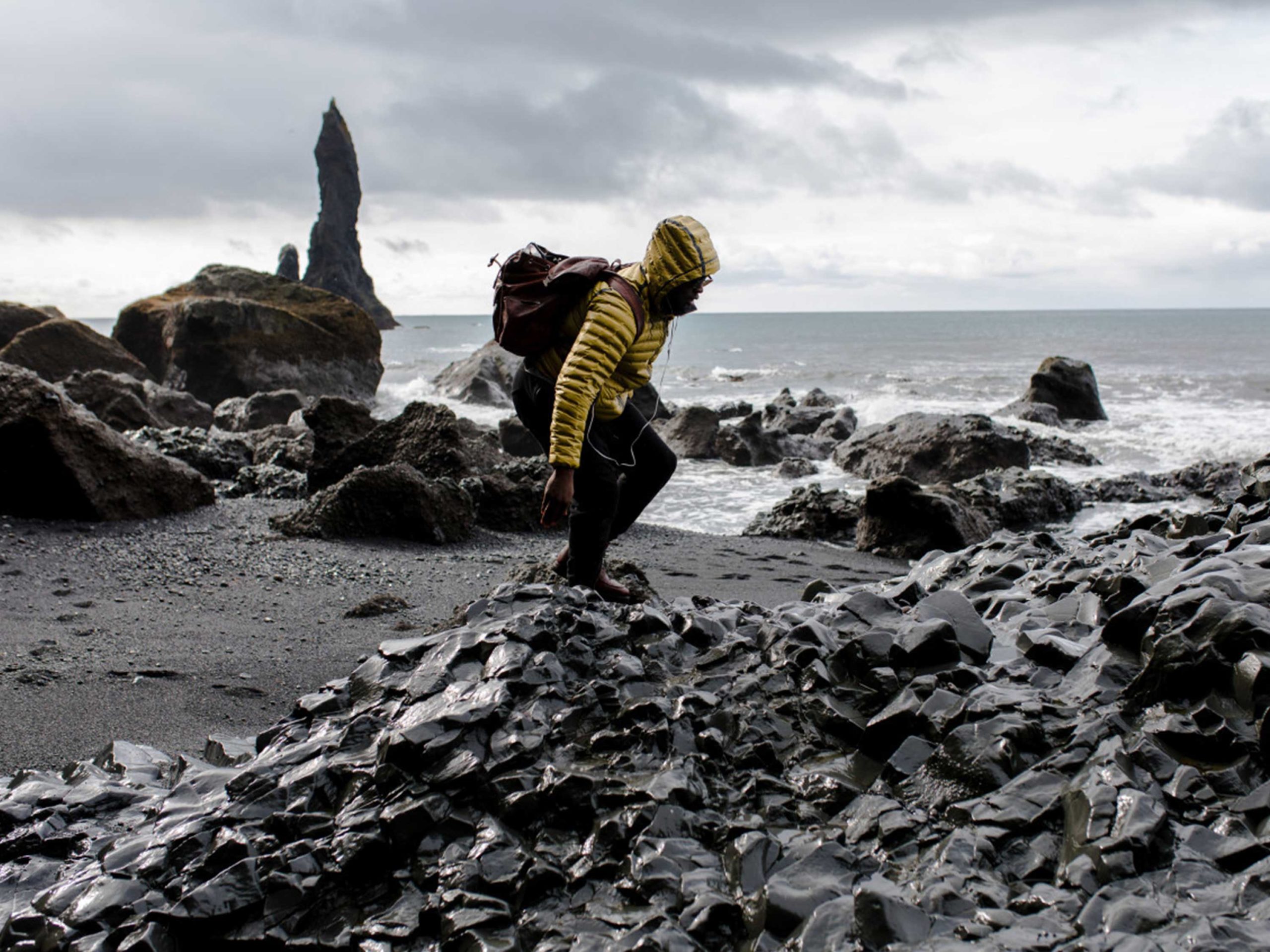 Person climbing rocks on a beach