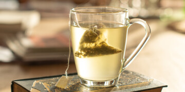 Glass mug of tea on a book