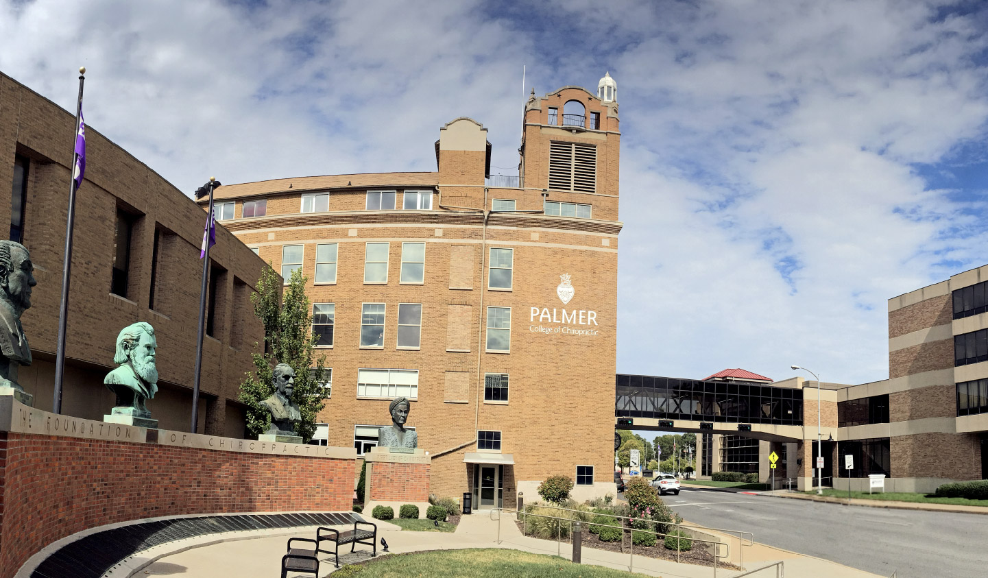 large brick building with a statue in front of it