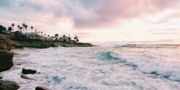 crashing waves with palm trees in the distance