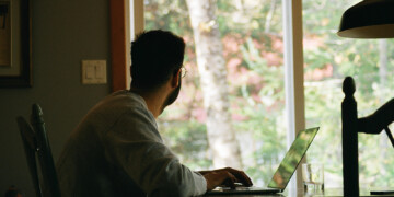 Person looking out the window while working