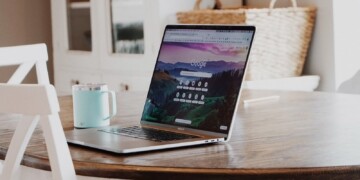 Laptop with Google browser on a table with a blue cup of coffee.