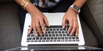 Person typing on a laptop computer.