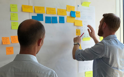 Two men reviewing user journey on post its