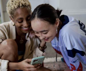 Two women looking at a phone.