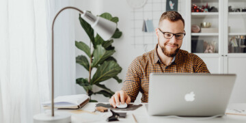 guy-smiling-while-working-on-computer