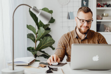 guy-smiling-while-working-on-computer