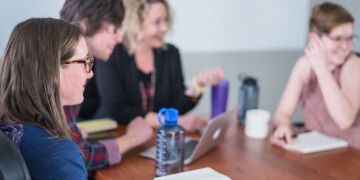 Four people gathering at a table.