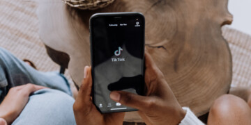 A close up of a person holding a phone with TikTok on the screen.