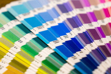 Close up of a rainbow array of Pantone color swatches.