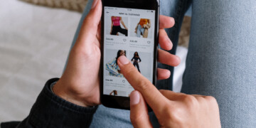 Close-up of person scrolling through clothing options on their cell phone.