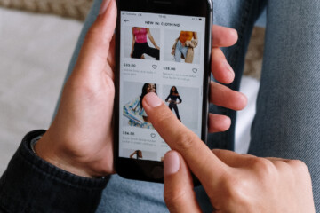 Close-up of person scrolling through clothing options on their cell phone.