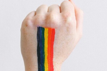 A fist with a rainbow painted on it.