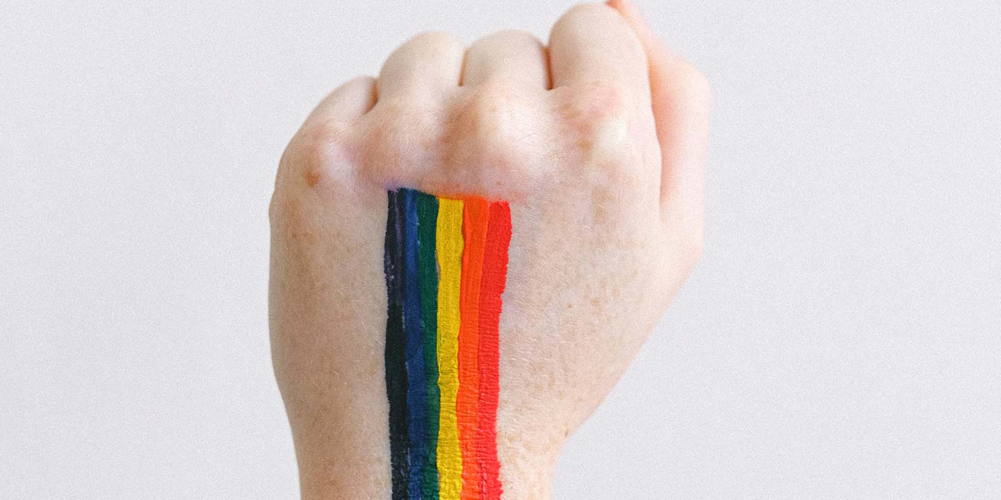 A fist with a rainbow painted on it.