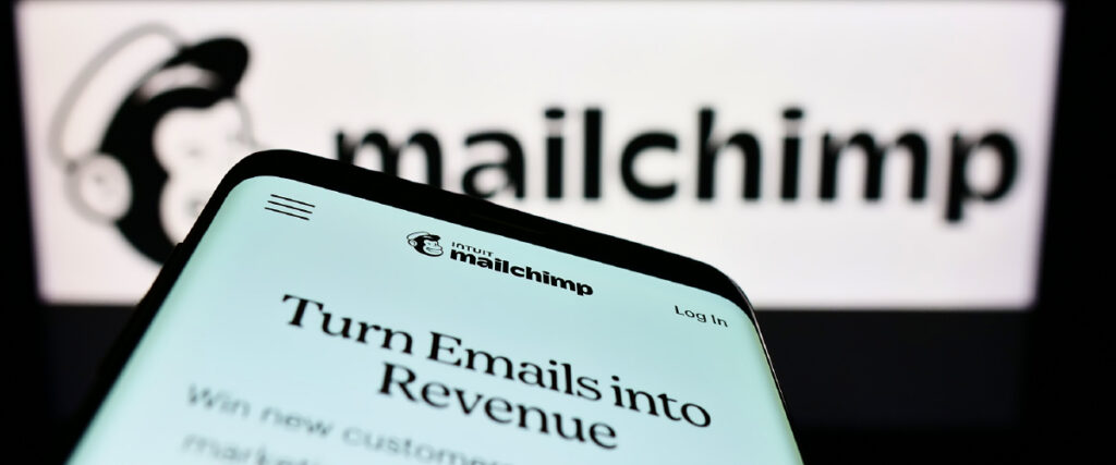 Phone and computer screens show the Mailchimp website and logo.