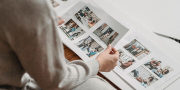 A person in a white shirt flips through a brand guide with photos of their target audience.